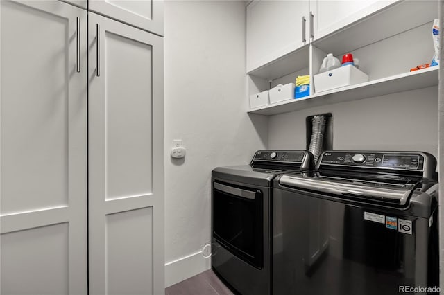 clothes washing area featuring washer and dryer and cabinets