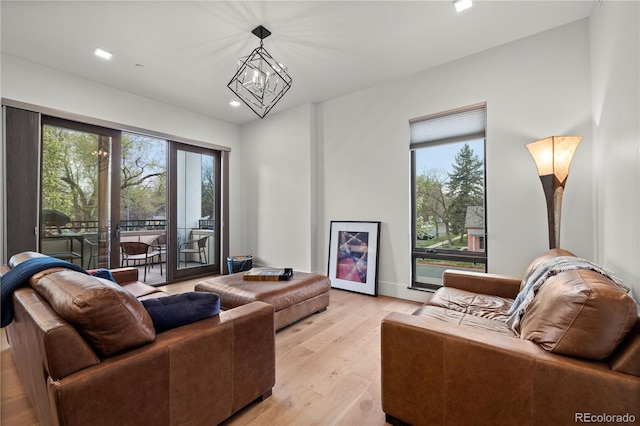 living room featuring an inviting chandelier and light wood-type flooring