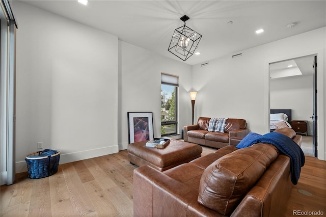 living room featuring an inviting chandelier and light hardwood / wood-style floors