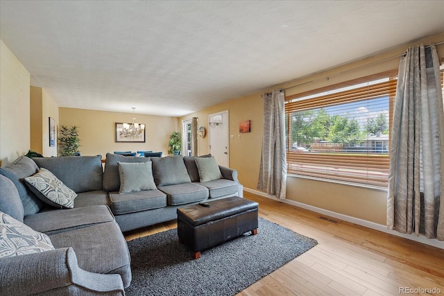 4855 E Atlantic Pl, Denver, CO 80222 - living room featuring a chandelier, light wood finished floors, and baseboards