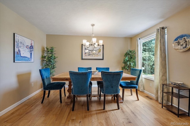 4855 E Atlantic Pl, Denver, CO 80222 - dining area with a chandelier, light wood finished floors, and baseboards