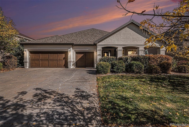 26781 E Clifton Dr, Aurora, CO 80016 - french country home with concrete driveway, a garage, stucco siding, a lawn, and a shingled roof