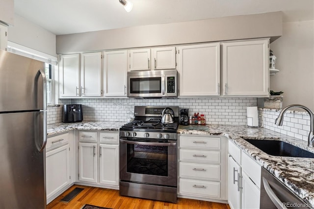 1818 S Quebec Way Unit 4, Denver, CO 80231 - kitchen featuring stainless steel appliances, a sink, white cabinets, open shelves, and backsplash