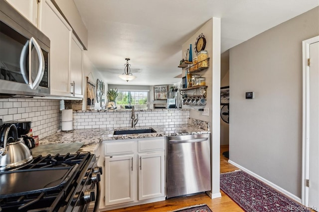1818 S Quebec Way Unit 4, Denver, CO 80231 - kitchen featuring appliances with stainless steel finishes, a sink, light wood-style floors, backsplash, and light stone countertops