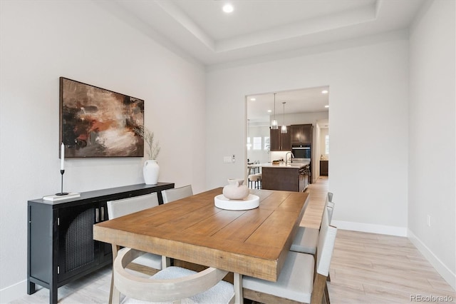 22183 E Rocky Top Pl, Aurora, CO 80016 - dining space with light wood-style floors, recessed lighting, and a tray ceiling