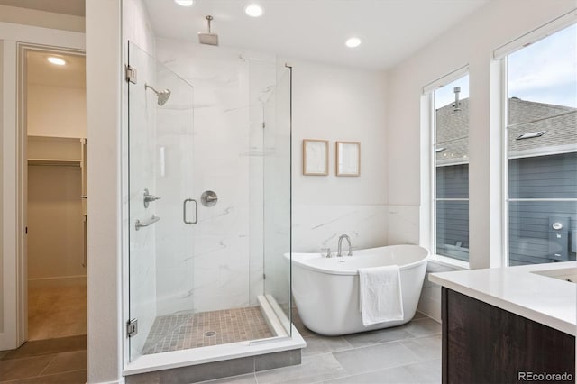 22183 E Rocky Top Pl, Aurora, CO 80016 - full bathroom featuring a marble finish shower, a freestanding bath, a spacious closet, tile patterned floors, and vanity