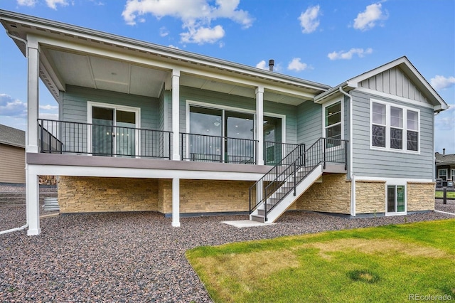 22183 E Rocky Top Pl, Aurora, CO 80016 - back of house with board and batten siding, stone siding, stairway, and a lawn