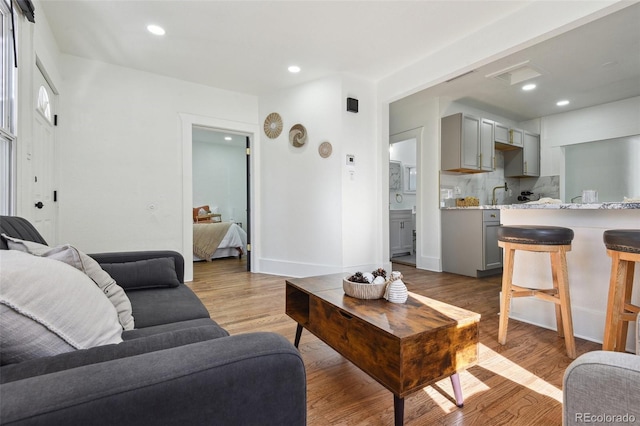 living room with sink and light hardwood / wood-style flooring