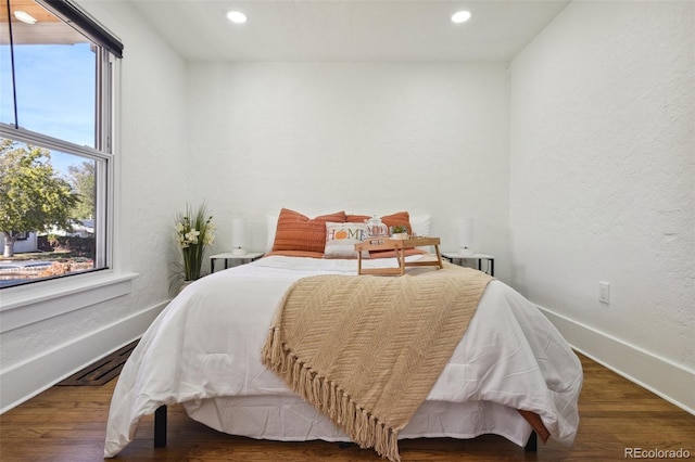 bedroom featuring dark wood-type flooring and multiple windows