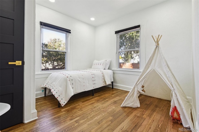 bedroom with wood-type flooring and multiple windows