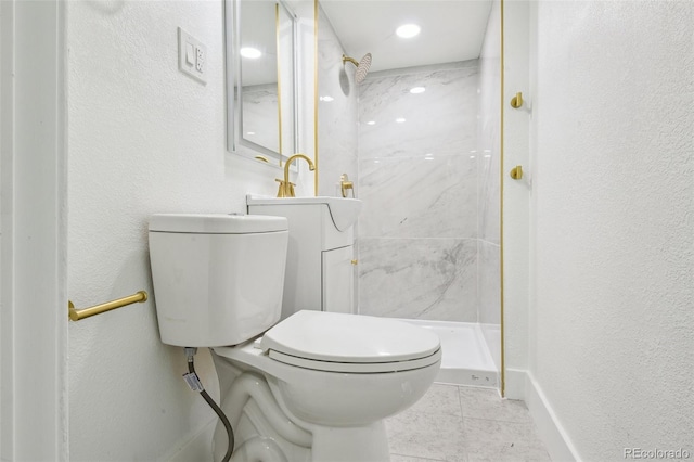 bathroom with vanity, toilet, and a tile shower