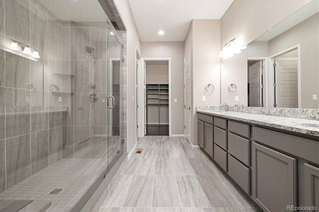 6725 Mentha Dr, Castle Rock, CO 80108 - full bath with a sink, double vanity, baseboards, a spacious closet, and a stall shower