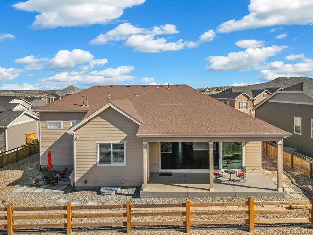6725 Mentha Dr, Castle Rock, CO 80108 - back of property with roof with shingles, a fenced front yard, and a patio area