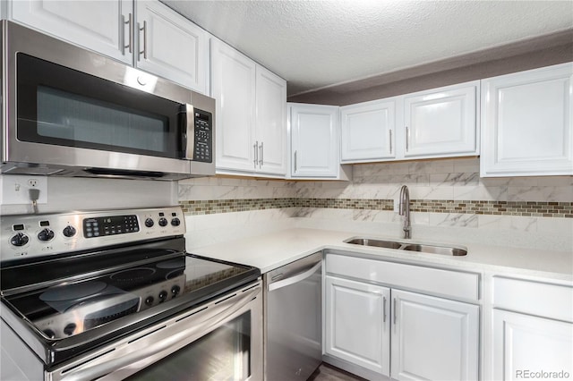 kitchen with white cabinetry, appliances with stainless steel finishes, sink, and tasteful backsplash