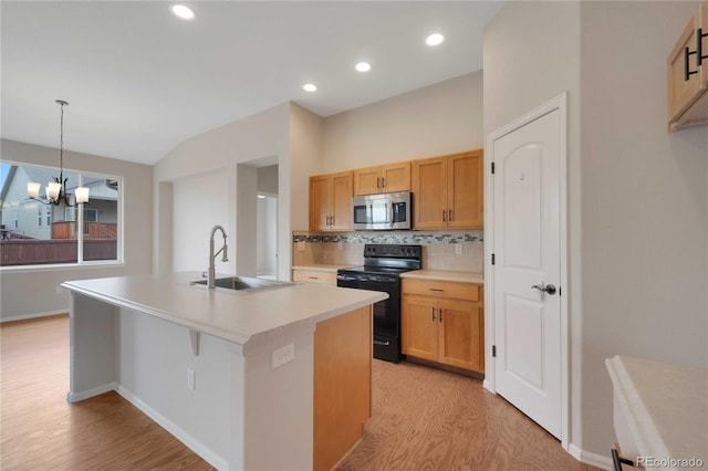 1867 Abundance Dr, Windsor, CO 80550 - kitchen featuring black range with electric cooktop, light wood-style floors, stainless steel microwave, a sink, and backsplash