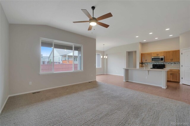 1867 Abundance Dr, Windsor, CO 80550 - unfurnished living room with baseboards, visible vents, ceiling fan with notable chandelier, and light colored carpet