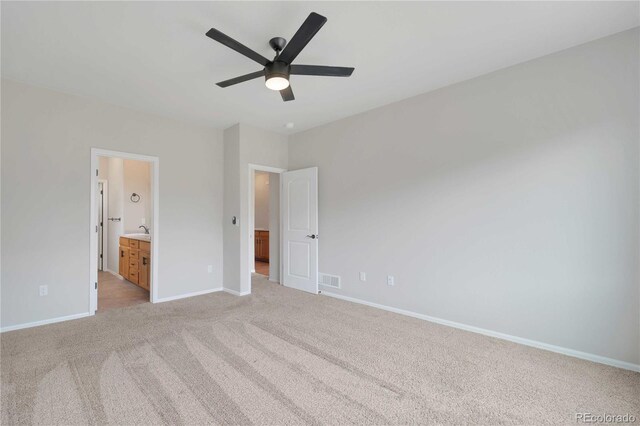 1867 Abundance Dr, Windsor, CO 80550 - unfurnished bedroom with light carpet, a sink, ensuite bath, baseboards, and visible vents