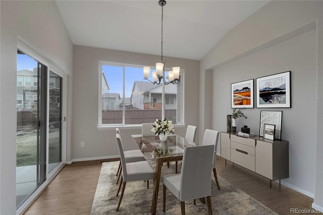 1867 Abundance Dr, Windsor, CO 80550 - dining room with baseboards, vaulted ceiling, wood finished floors, and a notable chandelier