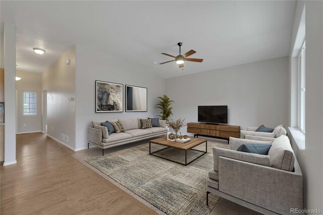 1867 Abundance Dr, Windsor, CO 80550 - living room with a ceiling fan, baseboards, wood finished floors, vaulted ceiling, and visible vents