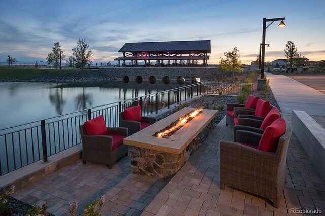 1867 Abundance Dr, Windsor, CO 80550 - view of patio featuring a water view and an outdoor fire pit
