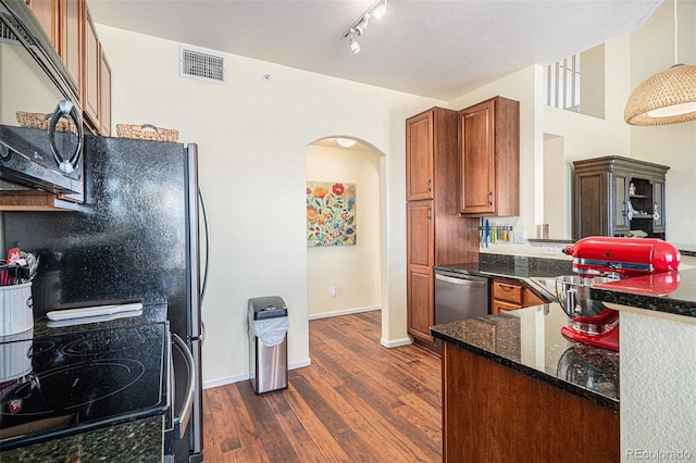 kitchen with dark wood-type flooring, electric range, stainless steel dishwasher, kitchen peninsula, and dark stone counters