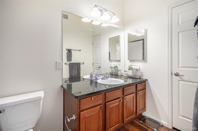 bathroom featuring vanity, hardwood / wood-style floors, and toilet