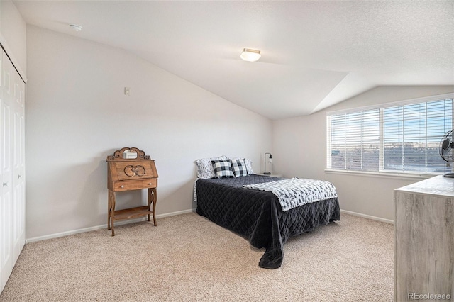 carpeted bedroom featuring vaulted ceiling and a textured ceiling