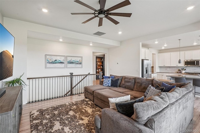 12841 Lake Port St, Longmont, CO 80504 - living room featuring light wood-style floors, a ceiling fan, and recessed lighting