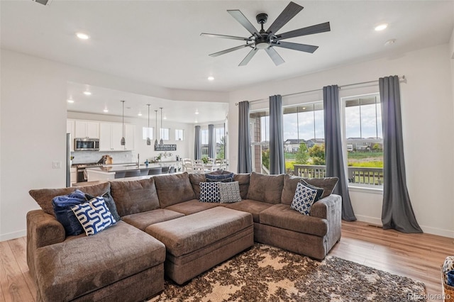 12841 Lake Port St, Longmont, CO 80504 - living room with light wood-style floors, a ceiling fan, and recessed lighting