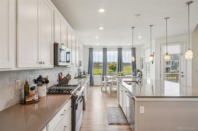 12841 Lake Port St, Longmont, CO 80504 - kitchen with appliances with stainless steel finishes, backsplash, white cabinetry, and recessed lighting
