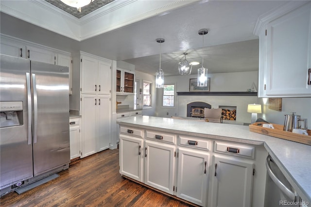 kitchen featuring dark wood-style floors, white cabinetry, light countertops, appliances with stainless steel finishes, and hanging light fixtures