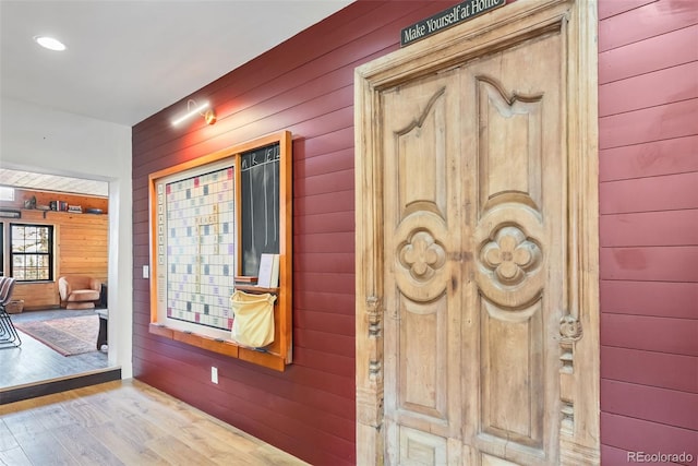 foyer with wooden walls and wood finished floors