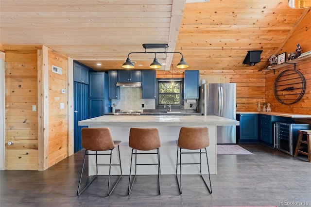 kitchen featuring blue cabinets, a sink, a kitchen breakfast bar, and stainless steel appliances