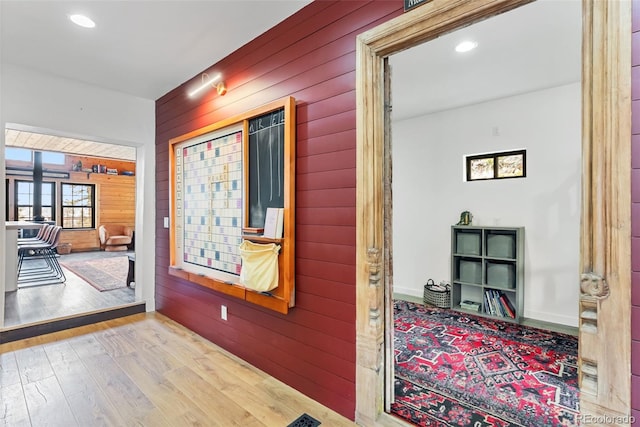 corridor with wooden walls, recessed lighting, and wood finished floors
