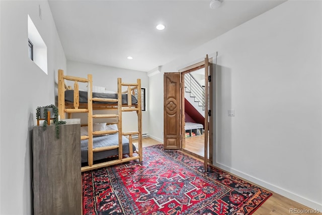 bedroom featuring baseboards, recessed lighting, and wood finished floors