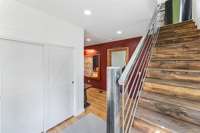 stairs featuring recessed lighting and wood finished floors