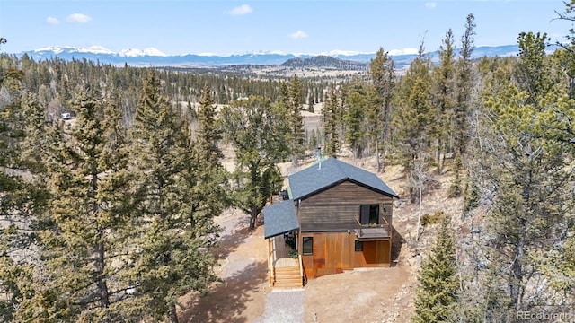 birds eye view of property with a wooded view and a mountain view