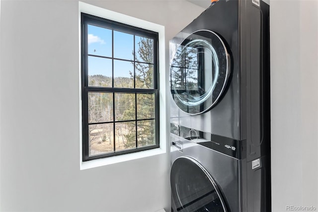 laundry area with stacked washer / drying machine and laundry area
