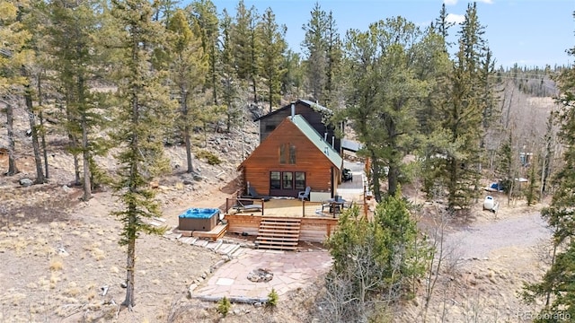 back of property featuring a view of trees and a wooden deck