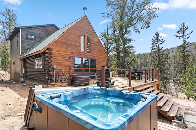 exterior space featuring a wooden deck and a hot tub