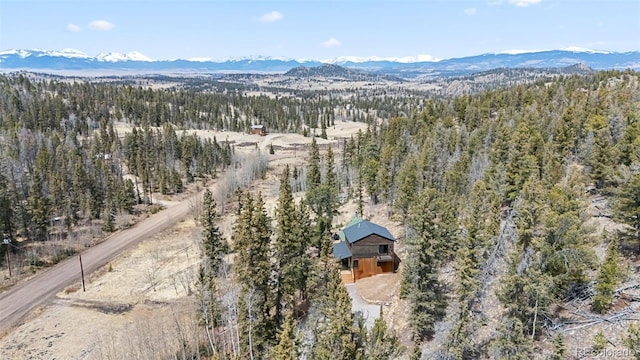 drone / aerial view featuring a forest view and a mountain view