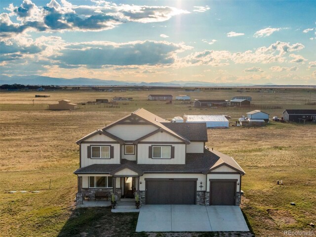 craftsman house featuring a garage, a rural view, and a front yard