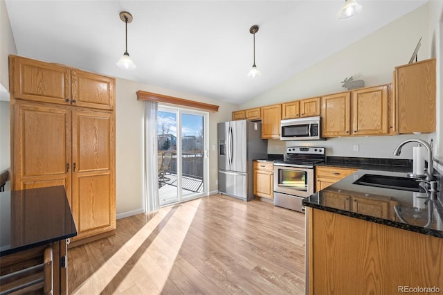 kitchen with sink, light hardwood / wood-style flooring, stainless steel appliances, decorative light fixtures, and dark stone counters