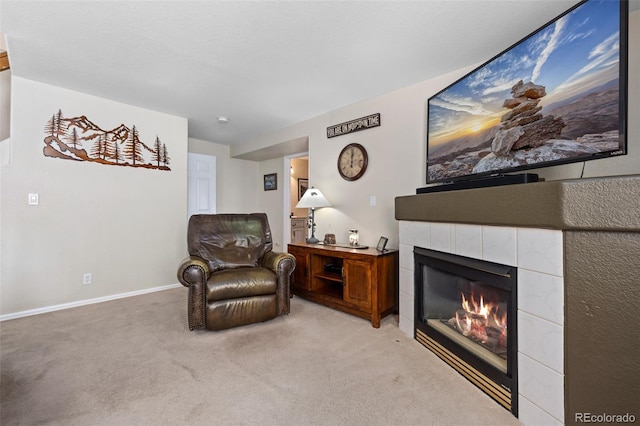 sitting room featuring a tiled fireplace and light carpet