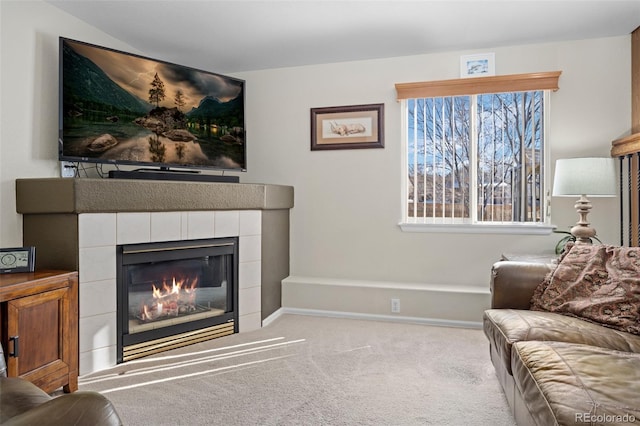 carpeted living room with a tile fireplace