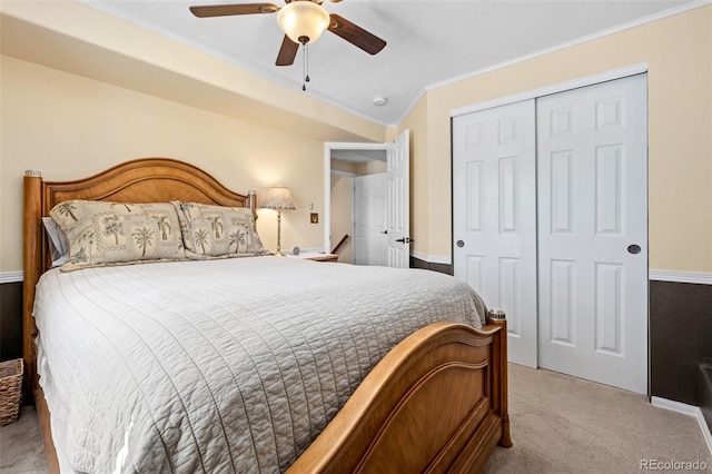 carpeted bedroom with ornamental molding, a closet, and ceiling fan