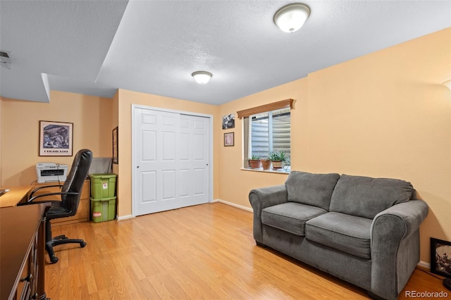 office with wood-type flooring and a textured ceiling