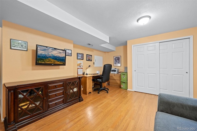 office space with a textured ceiling and light wood-type flooring