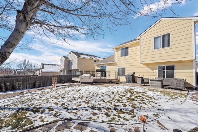 snow covered rear of property with outdoor lounge area and a deck