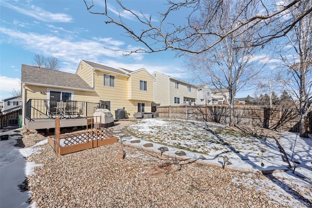 snow covered back of property featuring a deck